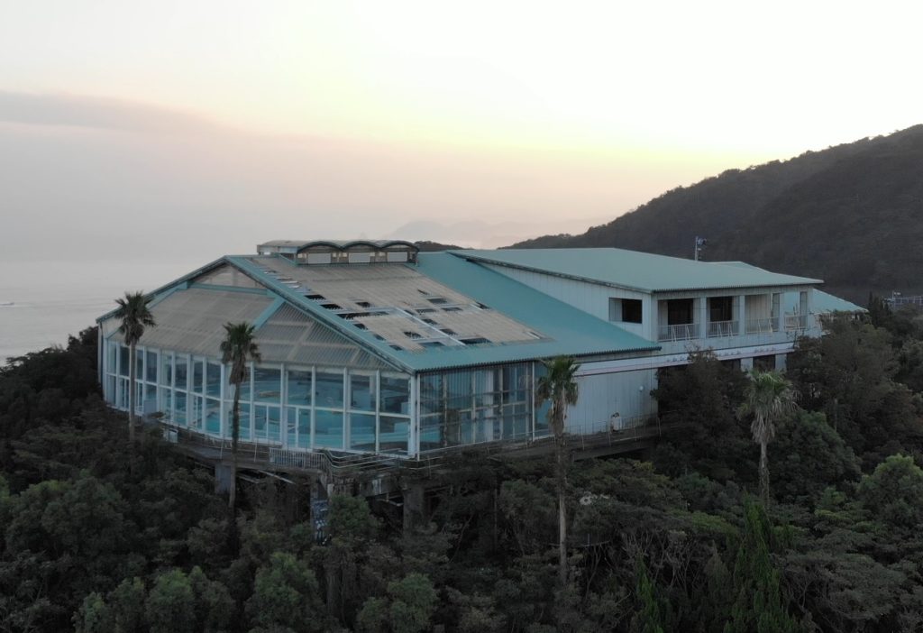 Centre de bien-être abandonné au Japon, entouré d'arbres et avec vue sur l'océan