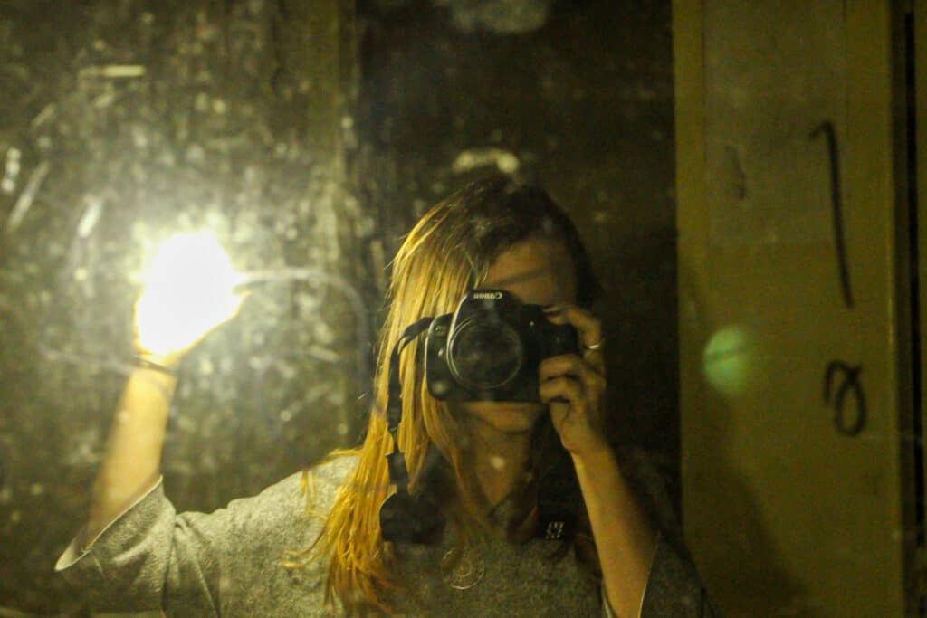 young woman takes a picture of herself in front of a mirror